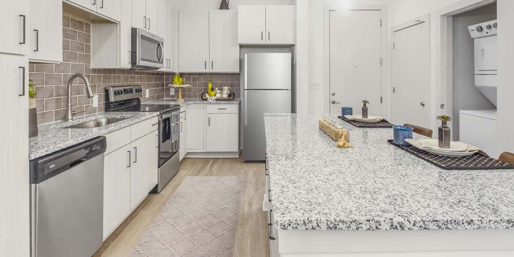 Kitchen with range, refrigerator, dishwasher and wooden cabinets at The Griff in Charlotte, North Carolina