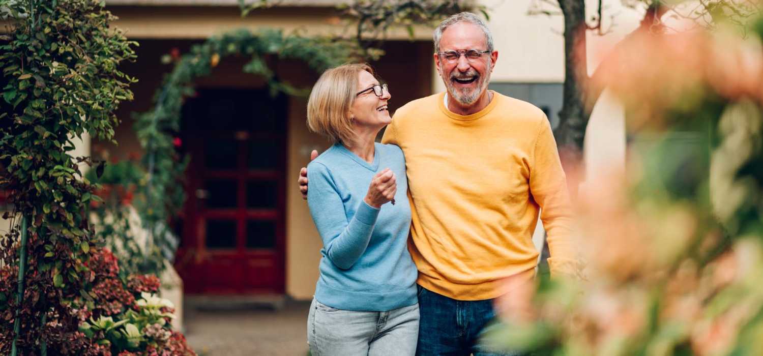 Senior couple heading out for a walk at Ellsworth Commons Apartments in Greenville, North Carolina