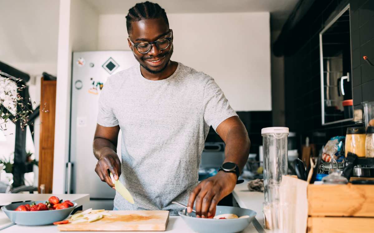 Resident man preparing food in the kitchen at El Cid Apartments in West Palm Beach, Florida