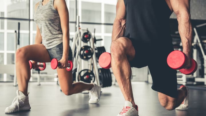 A male and a female working out with dumbbells in gym | gyms in Frisco