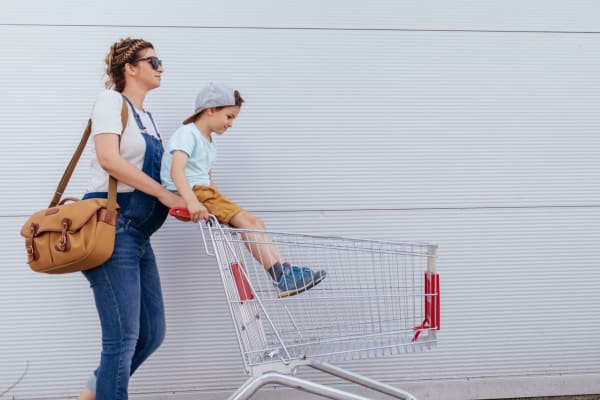 Resident mom pushing her son in a shopping cart at a grocer store near Forestbrook Apartments and Townhomes in West Columbia, South Carolina
