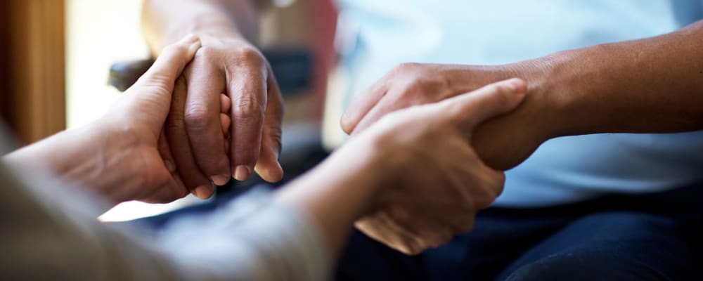 A staff member holding a residents hands at Ridgeline Management Company in Rockwall, Texas