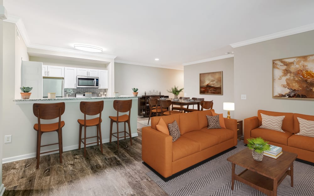 Staged living room with vinyl plank floors and open concept kitchen at Bishop's View Apartments & Townhomes in Cherry Hill, New Jersey