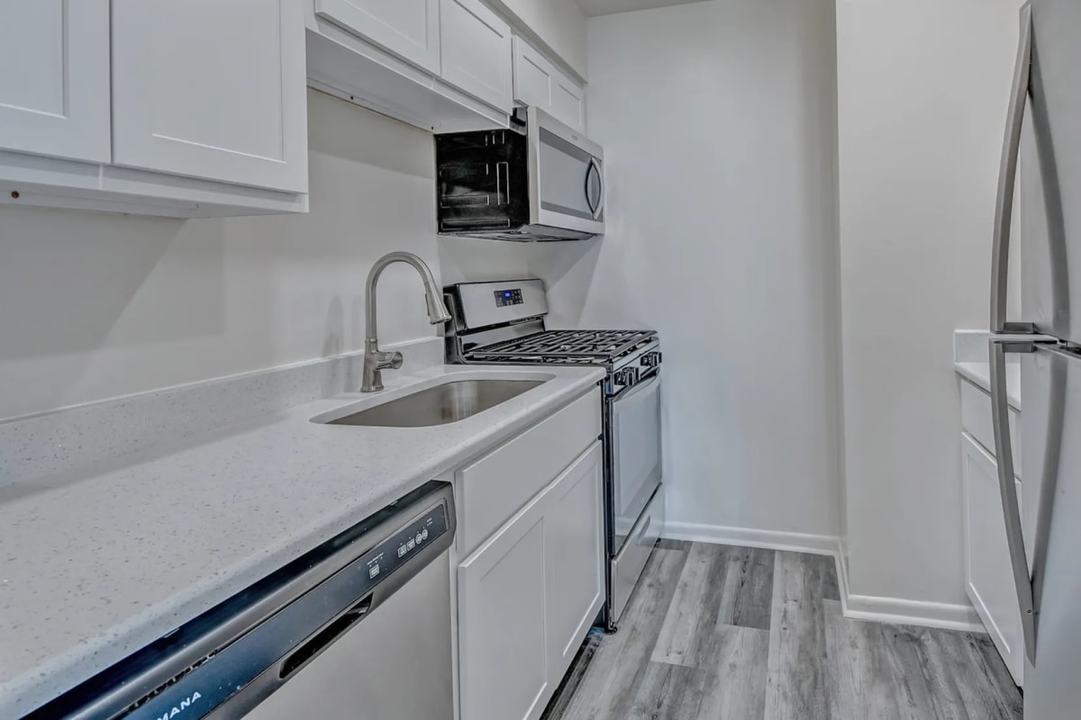 Bright kitchen with wooden cabinets and a dishwasher at Woodside Village in Valparaiso, Indiana