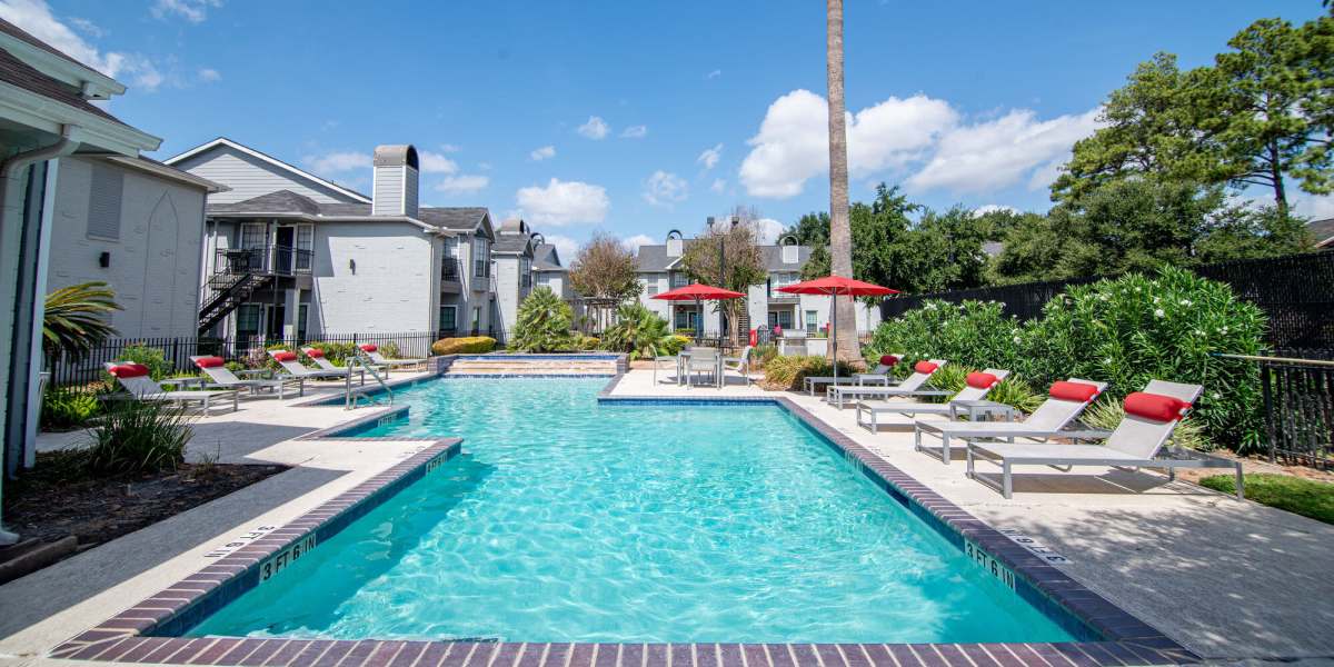 Sparkling swimming pool with sun deck, lounge chairs at Green Tree Place in Houston, Texas