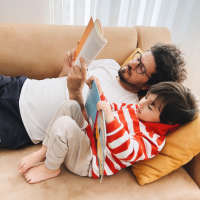 Residents reading book on the sofa at Barcelo Apartment Homes in San Antonio, Texas