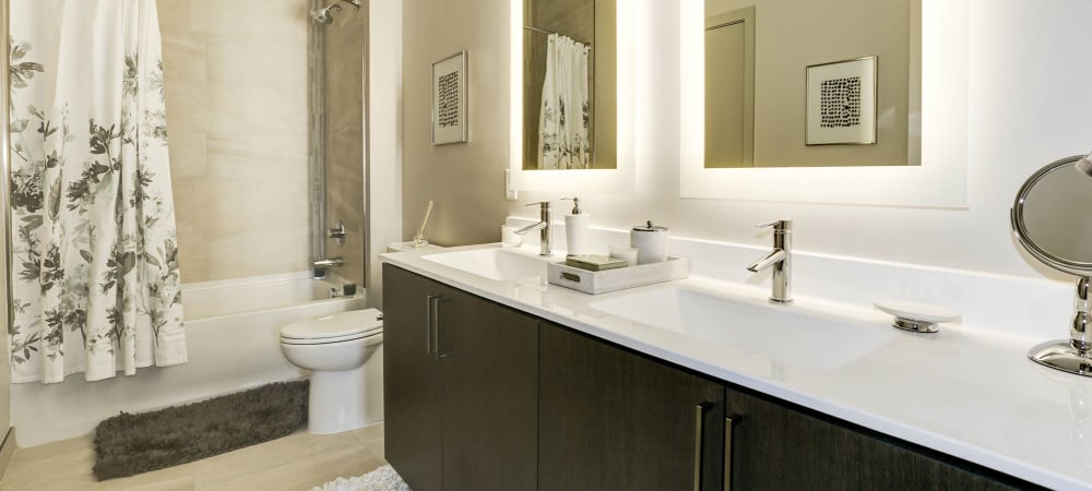 Spacious bathroom with large mirror and ample counter space at The Met Rockville in Rockville, Maryland
