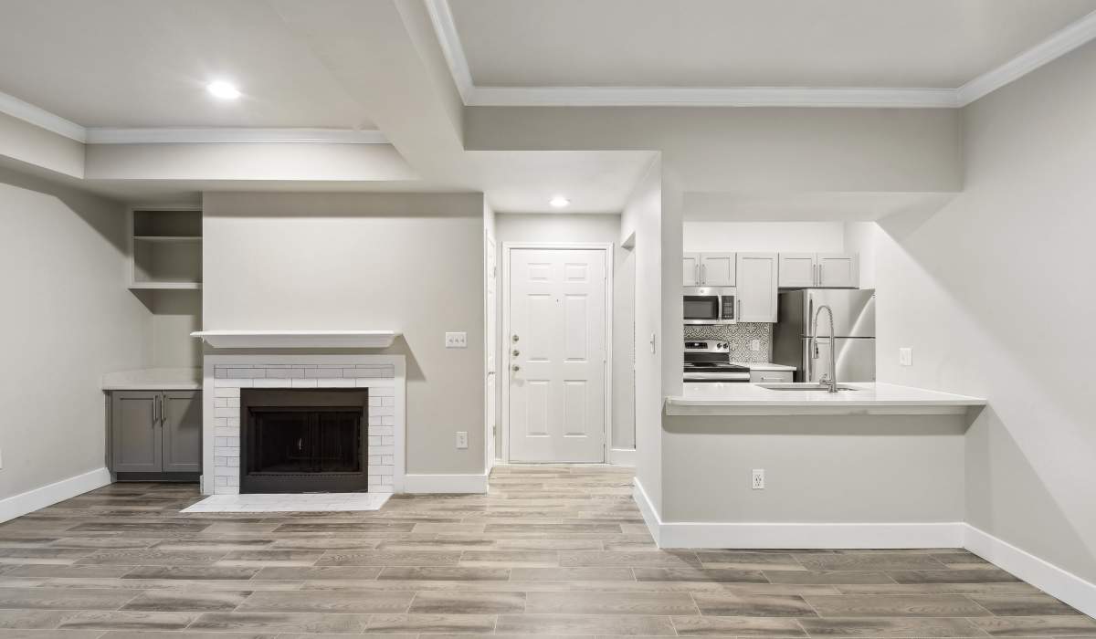 Spacious apartment living room with wood-style flooring and fireplace at Charleston in San Antonio,Texas