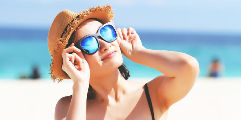 A woman putting sunglasses on at the beach near Lofgren Terrace in Chula Vista, California