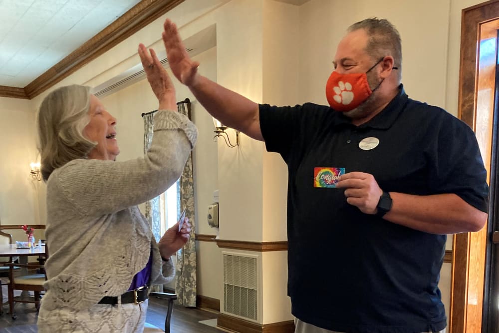 Residents and staff giving each other a high five at The Clinton Presbyterian Community in Clinton, South Carolina