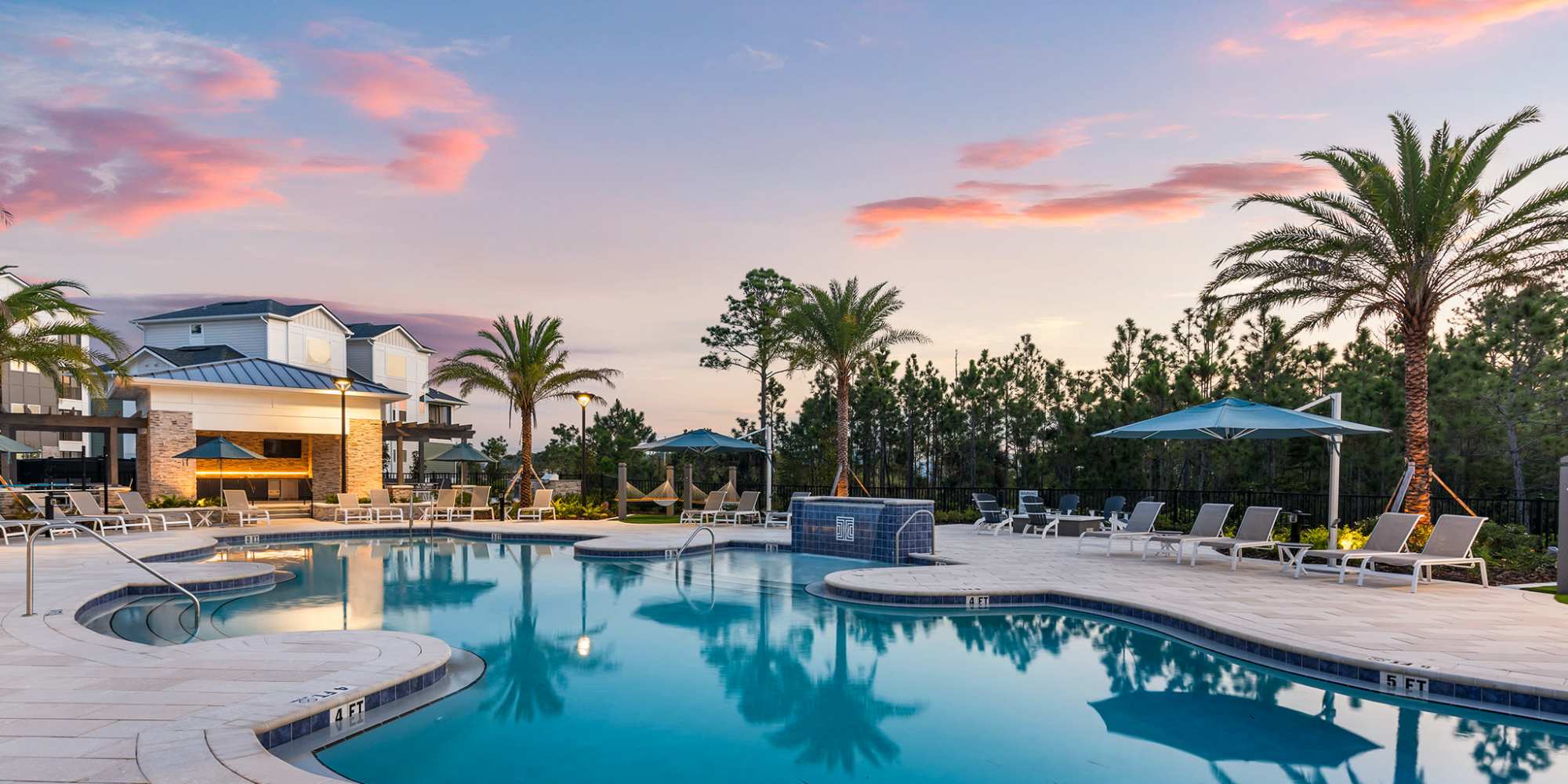 Clubhouse and exterior grills with hammocks Apply Now at Integra Village at Tymber Creek in Daytona Beach, FL
