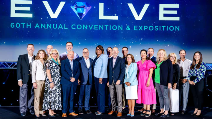 LeadingAge Florida conference picture with "EVOLVE" sign and 18 of its newest members