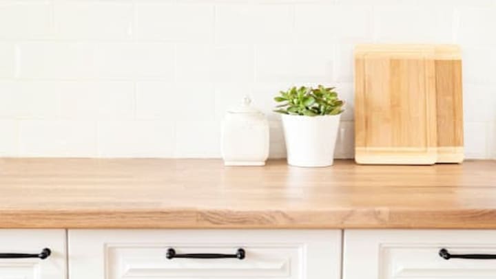 A bright and clean kitchen with white cabinets and butcher block counters.