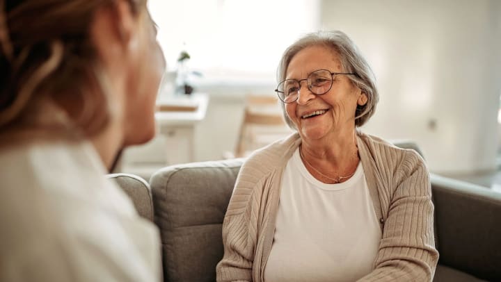 Senior woman smiling while having a conversation on the couch