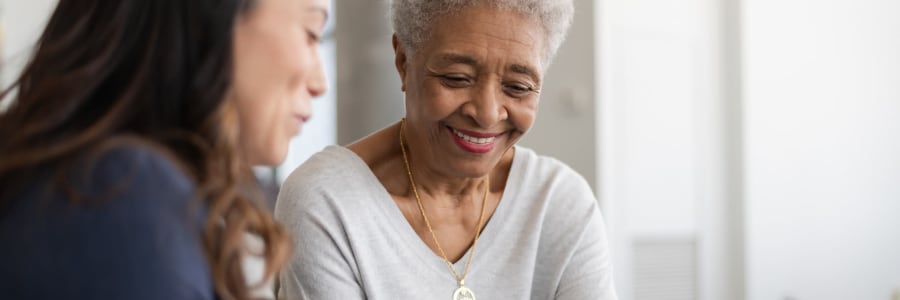 Resident sitting and talking with a caretaker at Villas At Maple Ridge in Spooner, Wisconsin