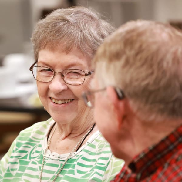 Two residents smiling while talking at The Wildwood Senior Living in Joplin, Missouri