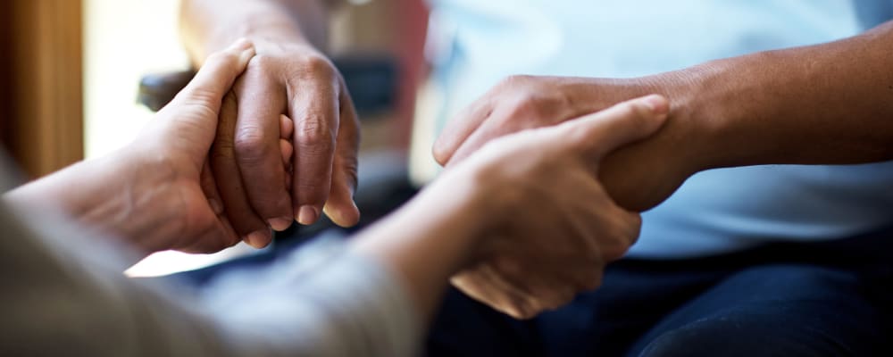 A staff member holding a resident's hands at Ridge at Frisco in Frisco, Texas