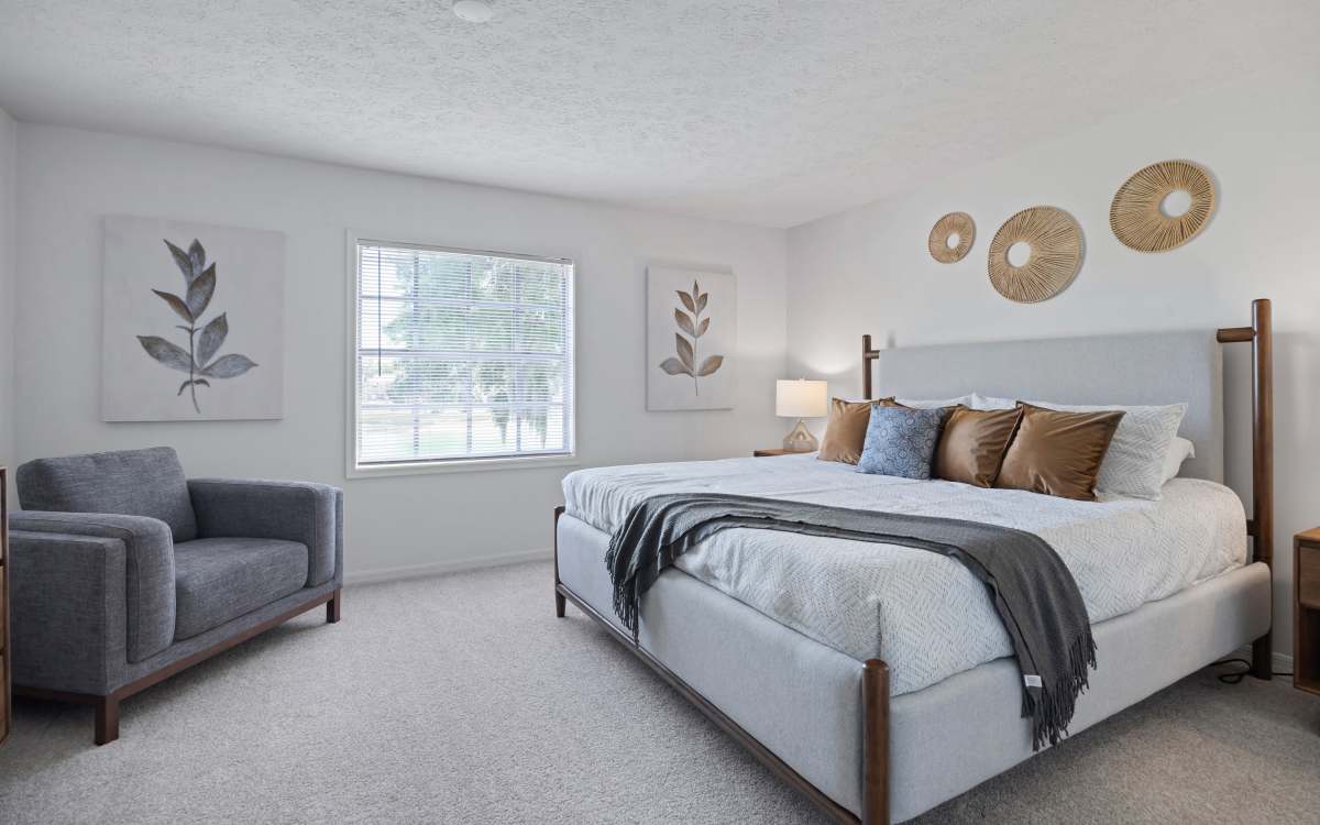 Stylish bedroom with cozy seating at Carlton Arms Of Magnolia Valley in New Port Richey, Florida 