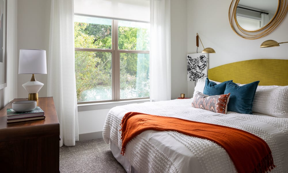 Furnished bedroom with large sun lit window at Bellrock Summer Street in Houston, Texas