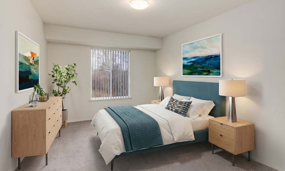 Model master bedroom with plush carpeting at Farmington Oaks Apartments in Farmington, Michigan