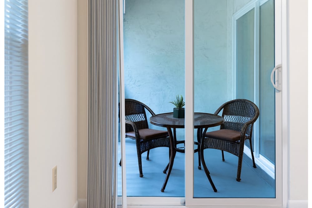 Spacious balcony with a glass door and cozy seating space at Fulton Hill Apartments in Tallahassee, Florida
