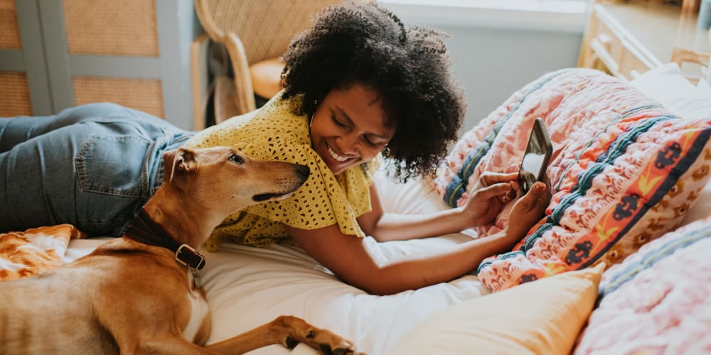 A resident on a bed with her dog at The Baldwin in Orlando, Florida