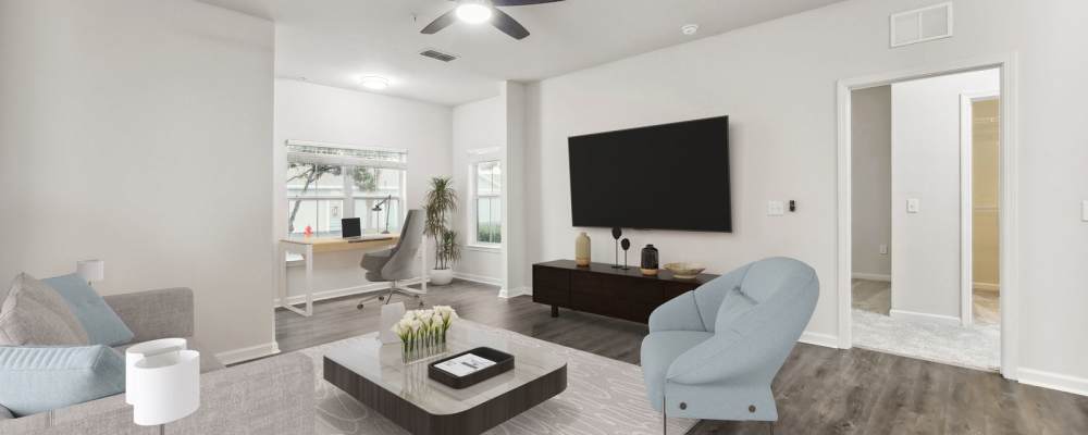 Specious living room with center table, television and computer desk at The Haven At West Melbourne in West Melbourne, Florida