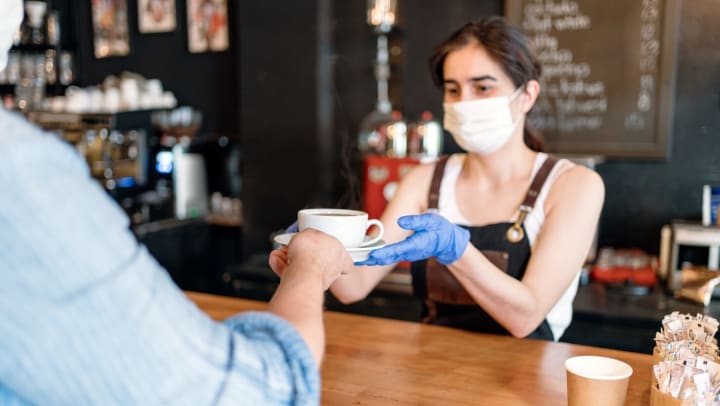 Woman serving coffee to customer 