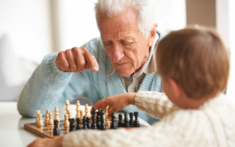 A resident playing a chess with his kid at Grand Villa of Deerfield Beach in Deerfield Beach, Florida