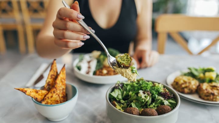 Woman holding a fork eating a falafel bowl | vegan and vegetarian restaurants near Albuquerque