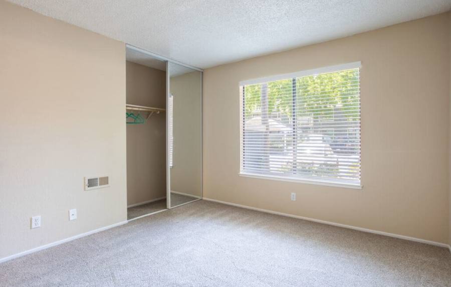 Unfurnished bedroom with closet and large window at Amber Court in Fremont, California