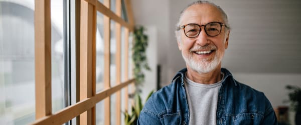 Man smiling while standing next to window at Lake Forest at Swift Creek in Midlothian, Virginia