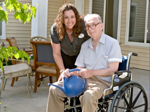 A staff member helping a resident water plants at Patriots Landing in DuPont, Washington. 