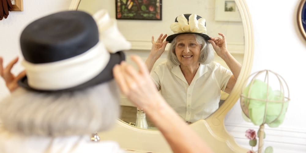 Resident modeling a necklace to a caretaker at a QSL Management community