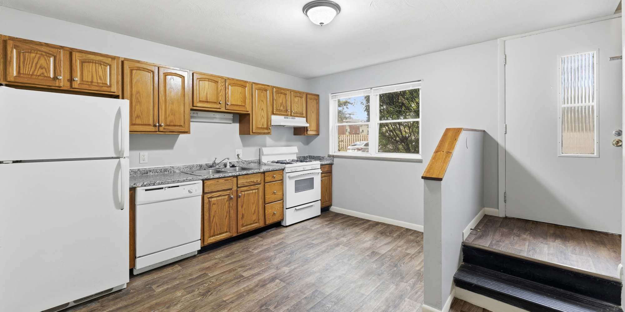 Modern kitchen with spacious layout and warm wooden cabinetry at The Reserve at Pin Oak Manor Apartments in Mishawaka, Indiana.