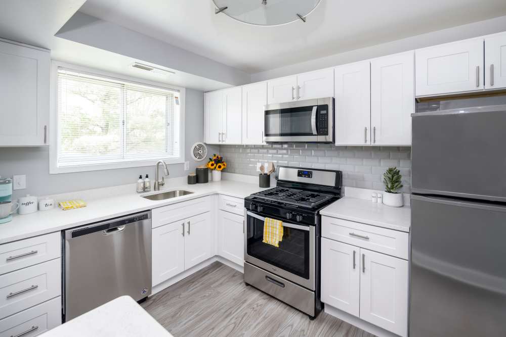 Fully equipped kitchen with granite countertops stainless steel appliances like a refrigerator, stove, and drawer microwave at Beacon Hill Apartments in Alexandria, Virginia