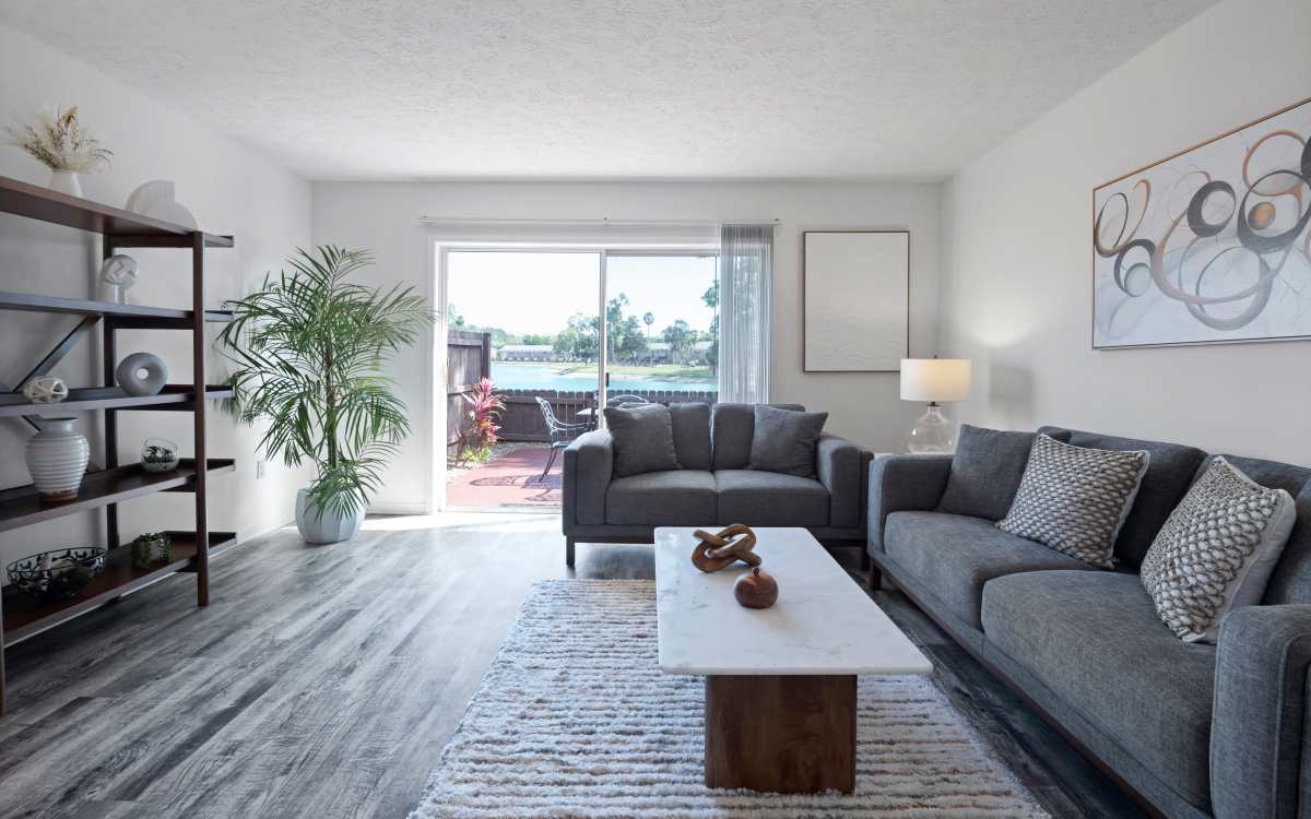 Modern living room with patio access at Carlton Arms Of Magnolia Valley in New Port Richey, Florida 
