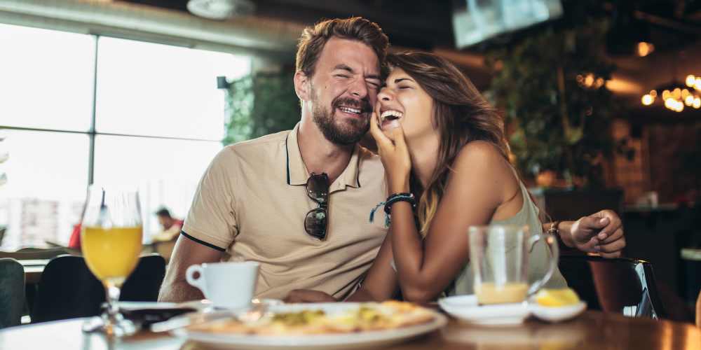 Resident couple sharing laugh over lunch near Central West End Apartments in Saint Louis, Missouri