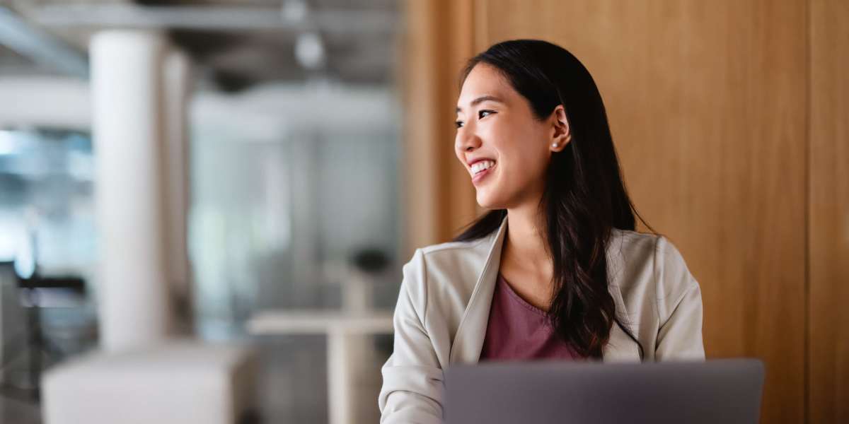 A woman smiling and working on her latop at Haverstock Hills in Houston, Texas