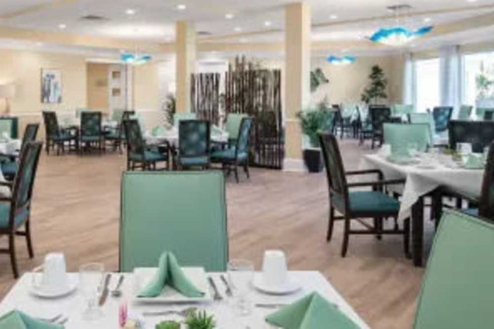 Community dining area with wood flooring at The Pineapple House at Sapphire Lakes in Naples, Florida