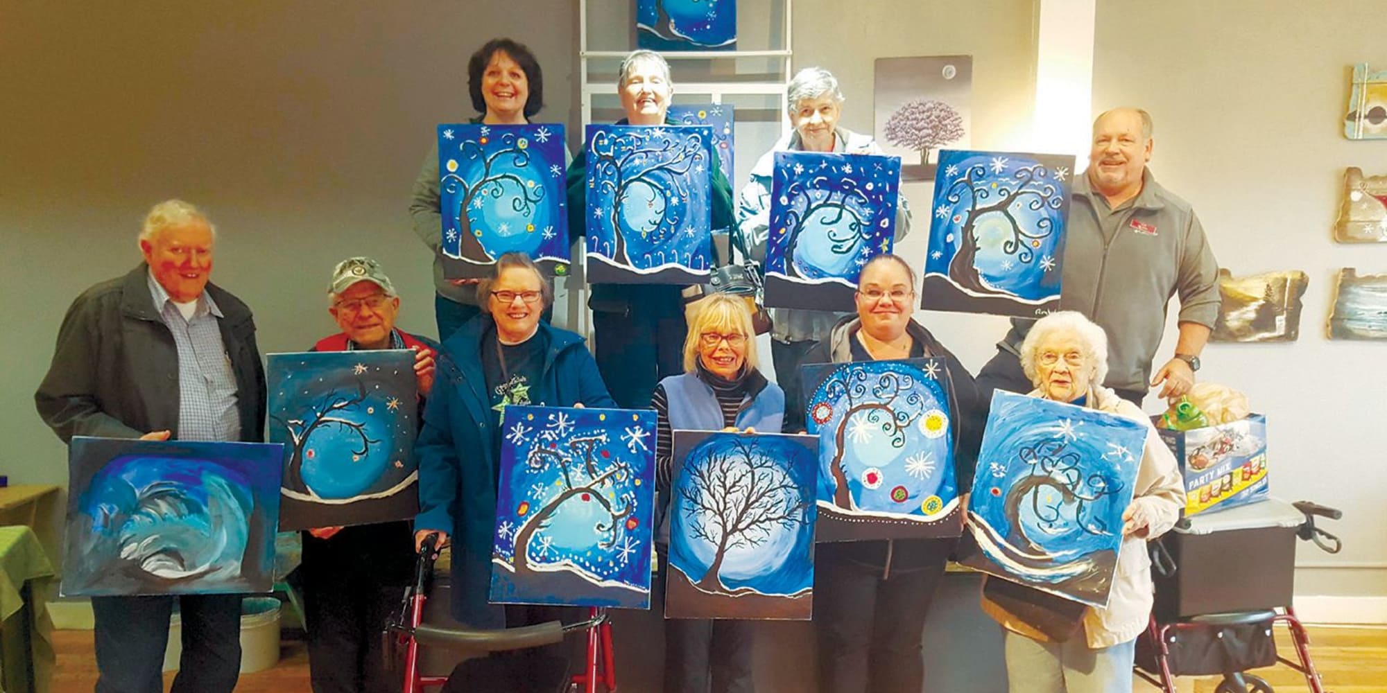 A group of residents with their paintings at Guelph Lake Commons in Guelph, Ontario