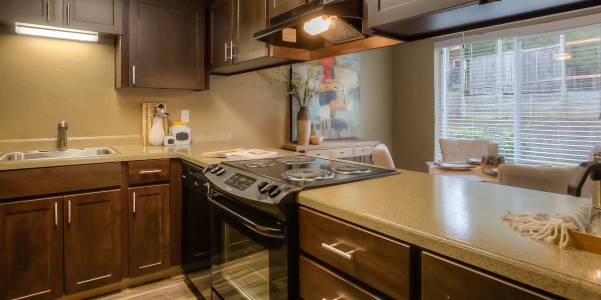 Apartment kitchen with warm interiors and wooden cabinetry at Oak Hill Apartments in Portland, Oregon
