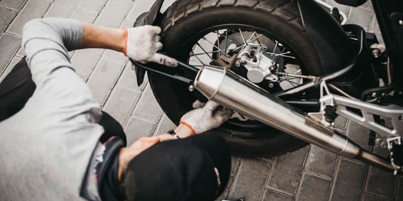 Resident working on his motorcycle in his garage at Adobe Flats V in Twentynine Palms, California