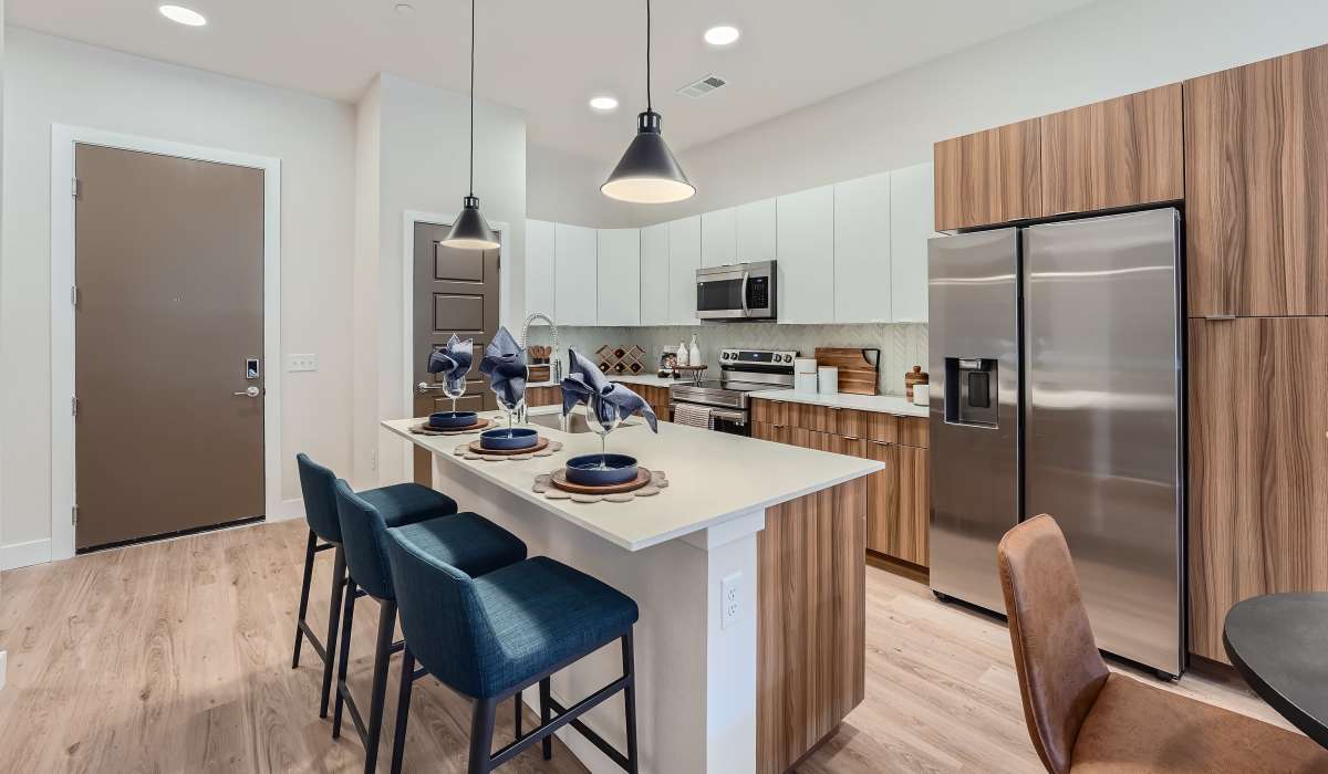 Spacious kitchen with steel appliances and bar counter at Flats on the A in Aurora, Colorado