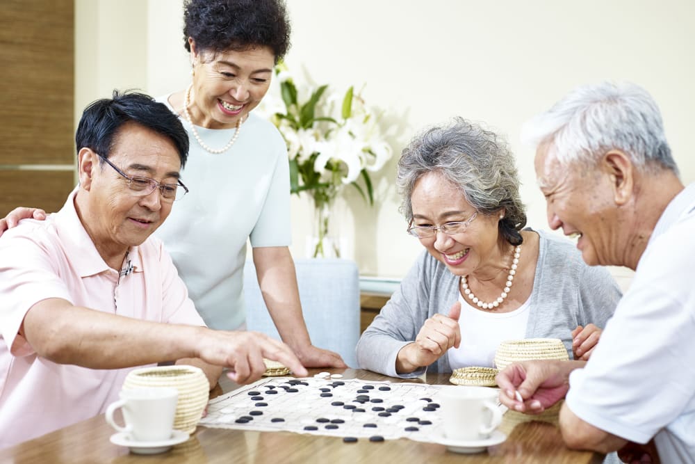 Two couples playing the Chinese game Go at Holden of Bellevue in Bellevue, Washington