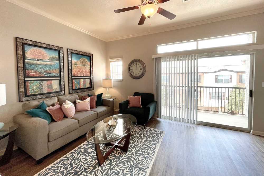 Living room with hardwood flooring and access to patio at The Abbey at Stone Oak in San Antonio, TX