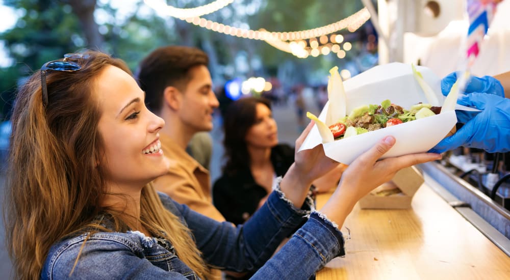 A woman grabbing food from a food truck near Astoria in Mobile, Alabama