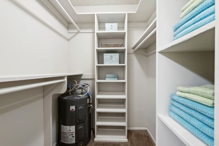 Interior of a large walk-in closet with built-in shelving at Executive Apartments in Miami Lakes, Florida