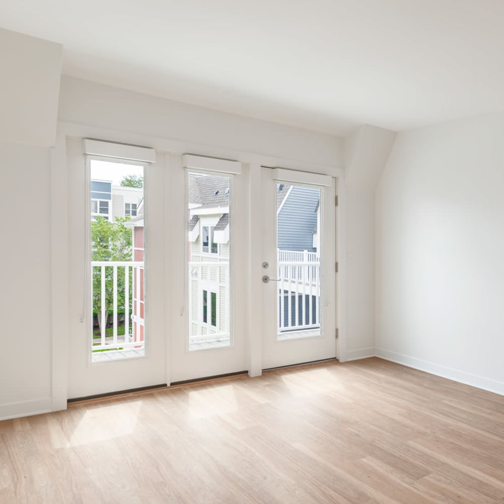 Living space with natural light and door to private balcony at Metro Green Court in Stamford, Connecticut