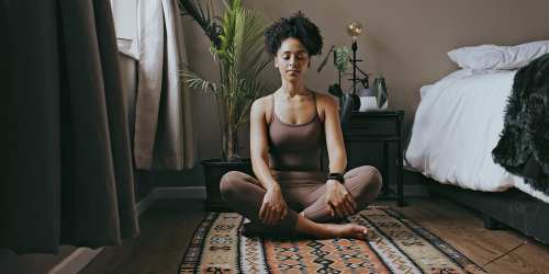 woman doing yoga in her spacious bedroom at Heron Hills Apartment Homes in Gresham, Oregon